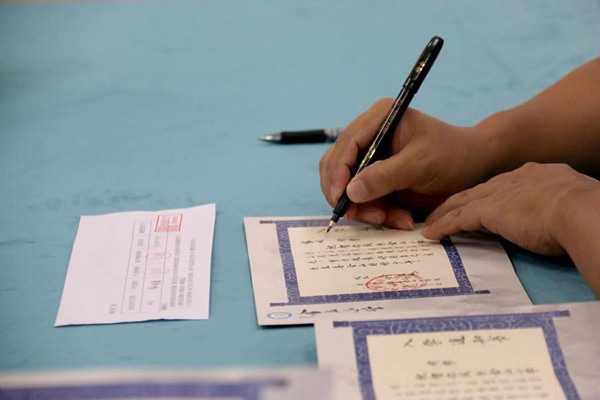 徐龍海在《入學通知書》上寫下學生名字。金山小學供圖