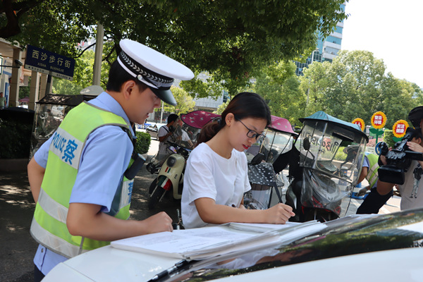 引導(dǎo)摩托車駕乘人員簽訂承諾書。黔江區(qū)委宣傳部供圖