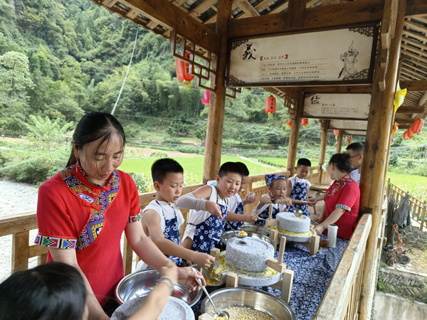 小朋友體驗研磨玉米。黔江區(qū)委宣傳部供圖