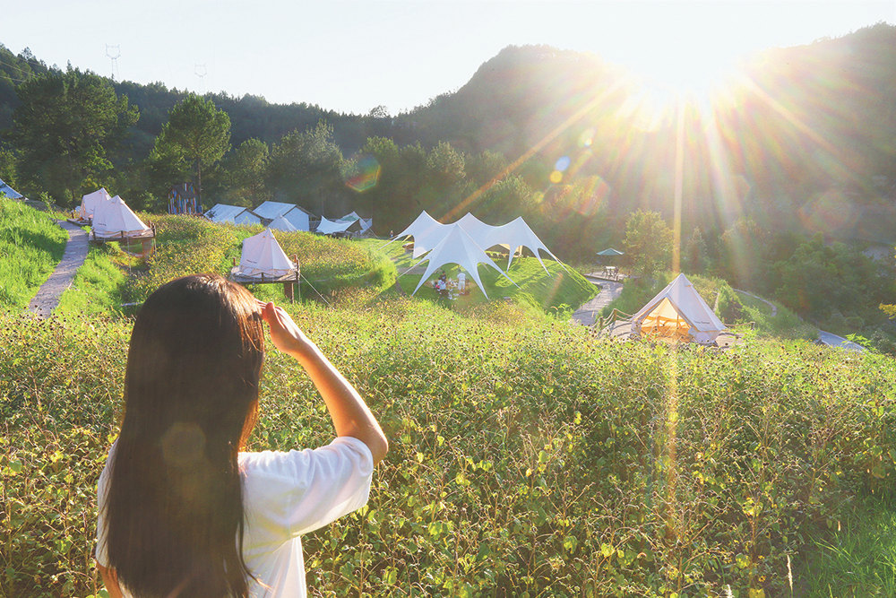 7月29日,石柱橋頭鎮(zhèn)喜馬拉雅野奢露營(yíng)地,游客以白色帳篷為背景拍照留念。特約攝影 鐘志兵/視覺(jué)重慶