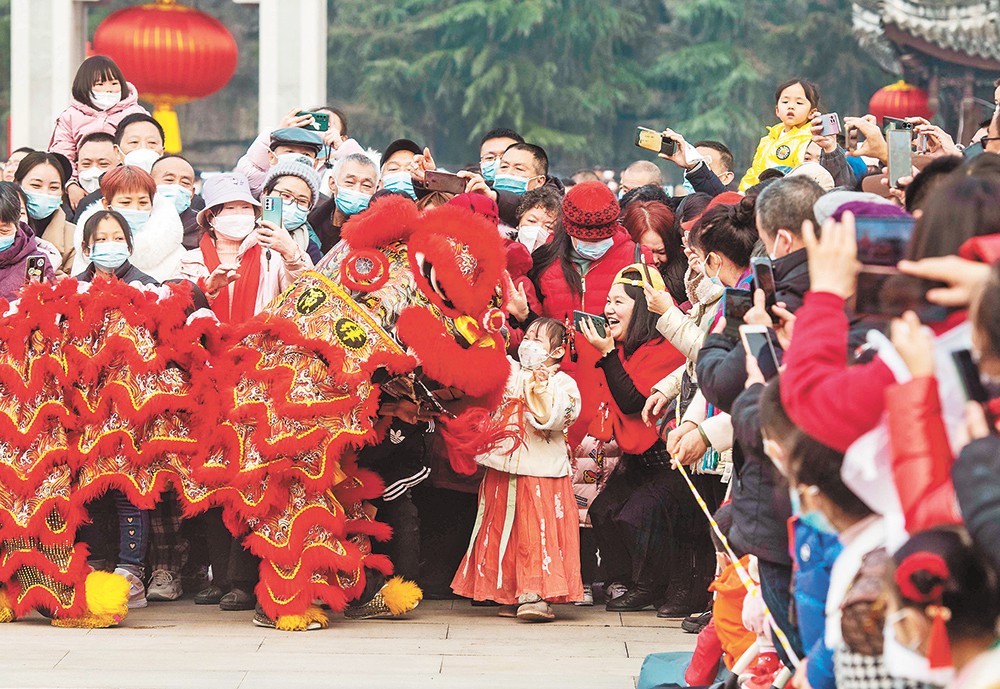 1月22日，園博園內(nèi)，小朋友摸著“獅子”興奮不已。 春節(jié)期間，園博園上演“龍獅鬧新春”、“歡樂新序曲”新春民樂會、“玉兔攬春光”以及年宵花展等活動，吸引不少市民前來游玩。記者 崔力 攝/視覺重慶