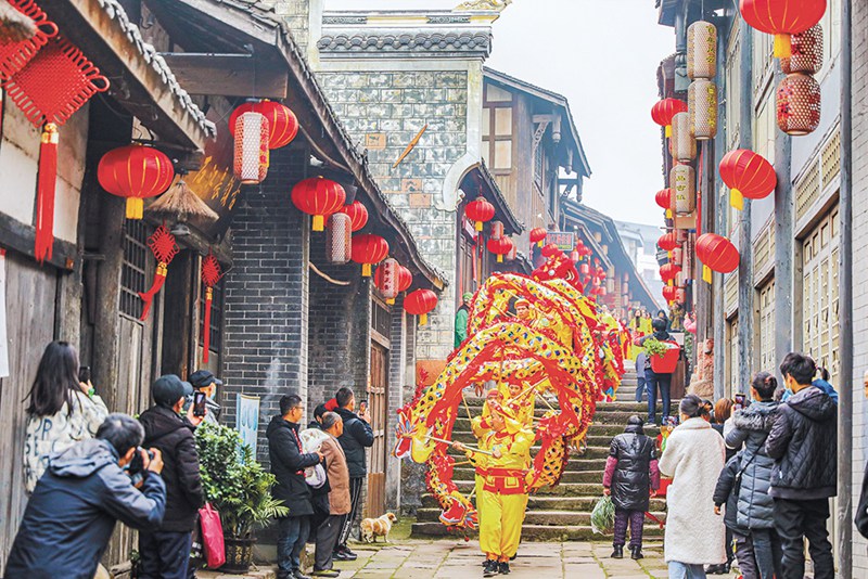 永川區(qū)松溉古鎮(zhèn)，穿行在街巷中的舞龍表演受到群眾的追捧。通訊員 陳科儒 攝/視覺(jué)重慶