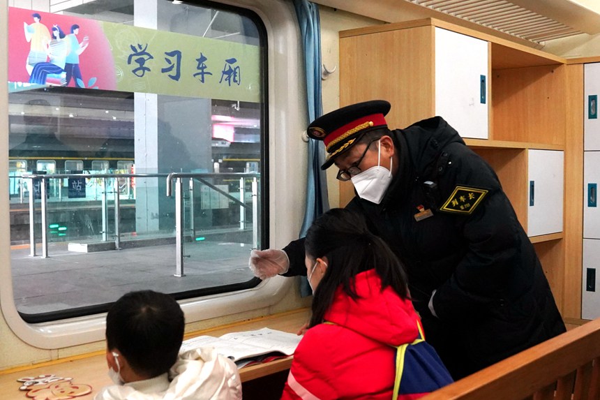 在5609次列車上，列車長王友為乘車的小學生講解車內服務設備。羅希雅攝