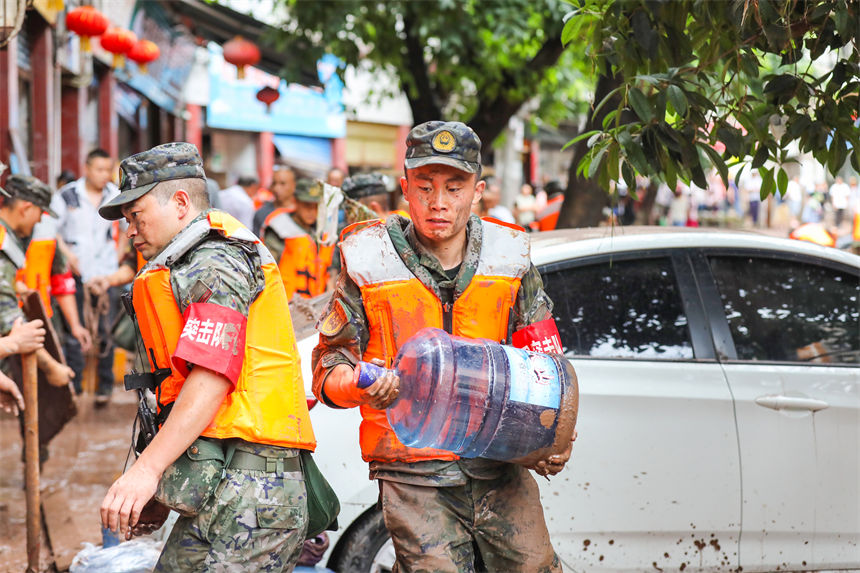 圖為武警官兵幫助受災(zāi)群眾轉(zhuǎn)移物資。李東攝