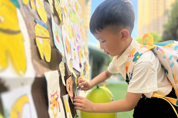 半島逸景園，孩子將“柚寶”貼到柚子樹上。大渡口幼教集團供圖