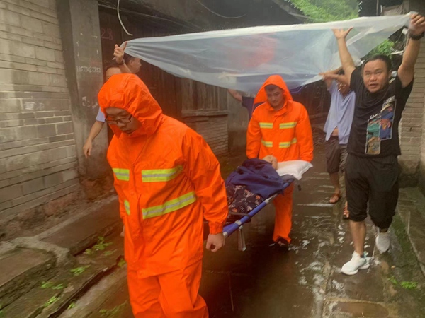 《緊急撤離》。8月2日強(qiáng)降雨之后，永川區(qū)松溉鎮(zhèn)駐守地質(zhì)工程師和鎮(zhèn)政府工作人員在巡查時(shí)發(fā)現(xiàn)有居民房屋發(fā)生地面沉降、墻體開裂等問題，立即開展了11戶受威脅群眾的緊急撤離工作。圖為工作人員正在幫助行動不便的老人轉(zhuǎn)移到安全地帶。  羅慶偉攝