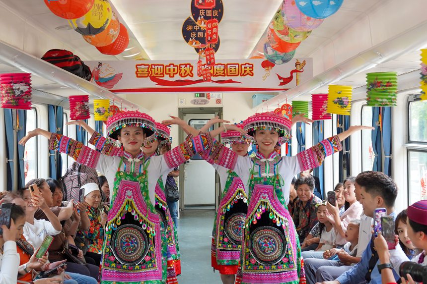 遵義開往重慶西的5630次列車上，桐梓縣文旅局演出人員為旅客表演非遺舞蹈。李文航攝