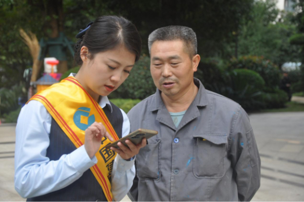 工作人員向居民講解“重慶渝快保”。重慶渝快保服務(wù)中心供圖