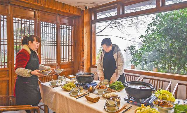 一月十五日，縉云村，“山之語(yǔ)”民宿老板周紅（右）正在為客人準(zhǔn)備美食。