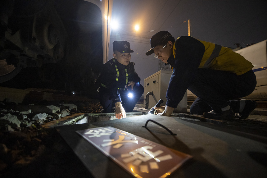 彭聰（左一）在重慶北動(dòng)車所工作人員的配合下，對存車場的地下式室外消火栓進(jìn)行檢查。胡勇攝