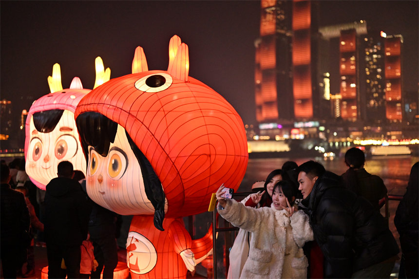 2月9日除夕夜，南岸區(qū)南濱路，燈光秀與重慶夜景交相輝映，吸引眾多市民前來(lái)觀看。郭旭攝