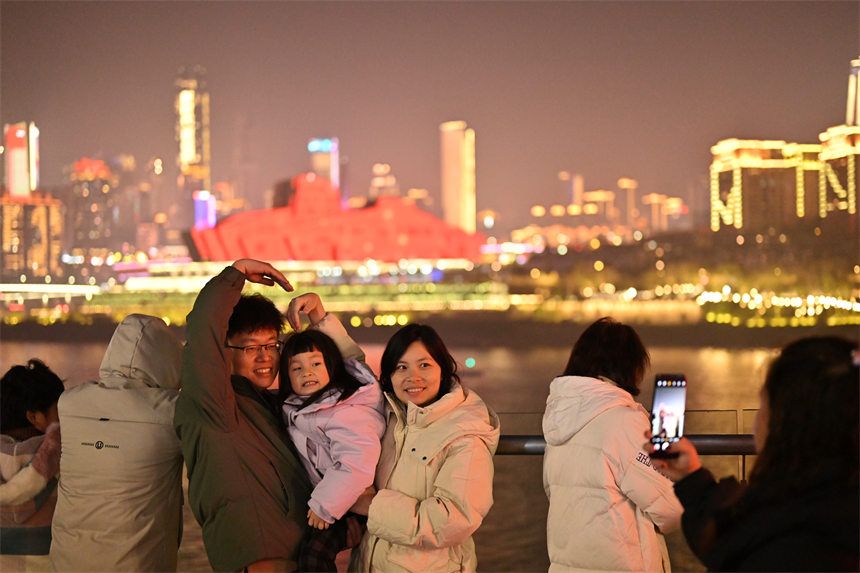 2月9日除夕夜，南岸區(qū)南濱路，燈光秀與重慶夜景交相輝映，吸引眾多市民前來觀看。郭旭攝