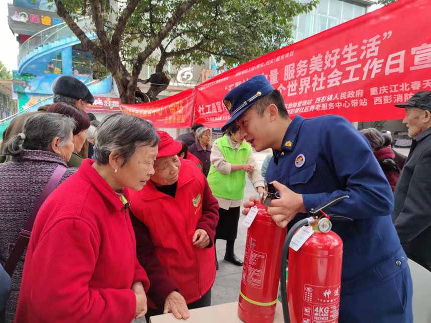 西彭消防救援站工作人員為居民講解滅火器的使用方法。主辦方供圖