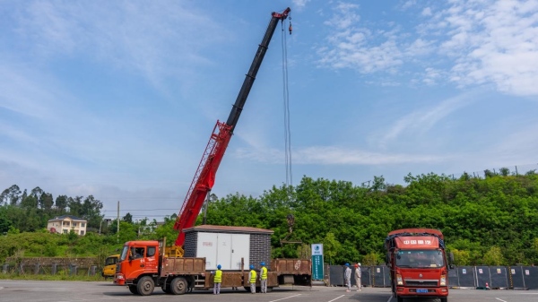 國網(wǎng)重慶電動汽車公司施工人員在對新建超充站的箱式變壓器進行吊裝作業(yè)。國網(wǎng)重慶市電力公司供圖