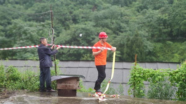 《警戒》。6月28日，綦江區(qū)石壕鎮(zhèn)一處斜坡突發(fā)滑坡險(xiǎn)情，重慶一三六地質(zhì)隊(duì)地災(zāi)駐守工程師鄧森木（右）配合當(dāng)?shù)卣ぷ魅藛T在現(xiàn)場處置，設(shè)置警戒范圍。杜健攝