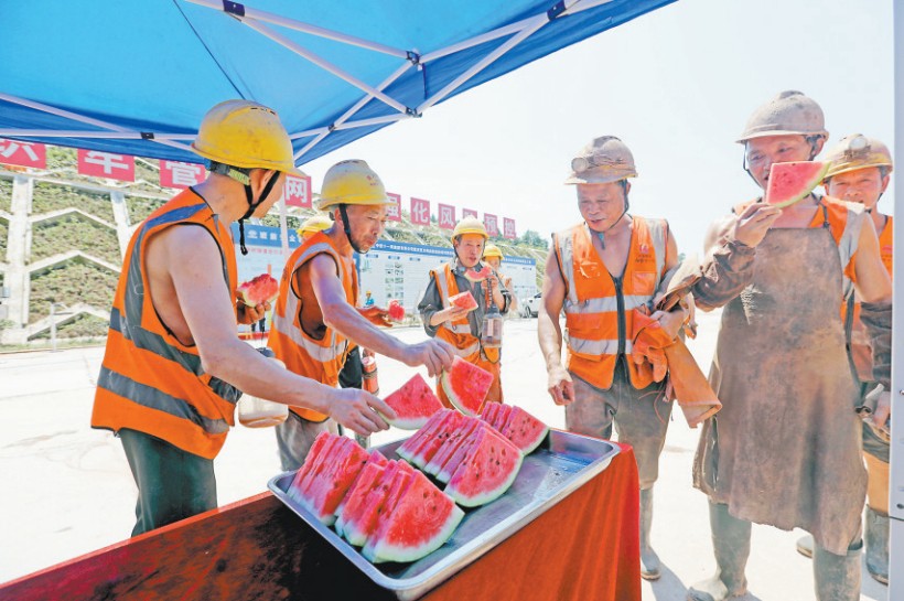 8月7日，渝萬高鐵站前1標(biāo)塔平村隧道出口，中鐵十一局的建設(shè)者正在清涼驛站吃西瓜解暑熱。記者 羅斌 攝/視覺重慶