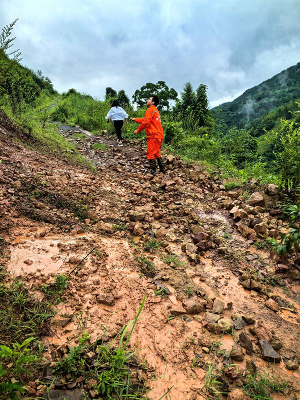 《雨后地災(zāi)巡查》。7月11日，巫山縣銅鼓鎮(zhèn)副鎮(zhèn)長溫利華、地質(zhì)駐守工程師王忠凌（右）雨后巡查銅鼓村柏果樹坪地災(zāi)點(diǎn)。劉勇攝