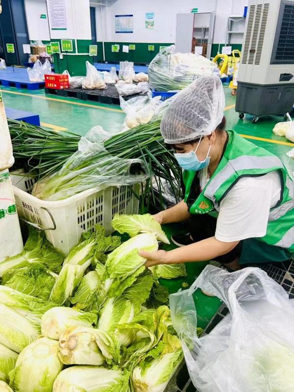 配送人員按照訂單精心挑選著各類新鮮的蔬果，確保每一份食材都符合質(zhì)量標(biāo)準(zhǔn)。豐都實(shí)業(yè)供圖。